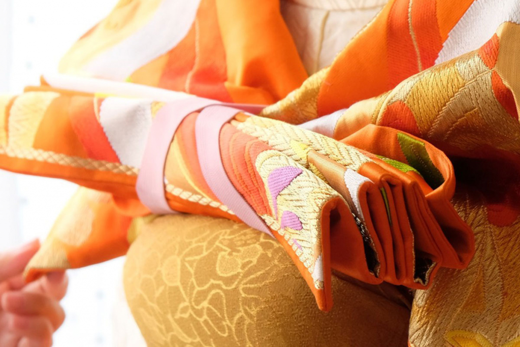 オレンジ色の袋帯を三重紐をつかって変わり結びしている所