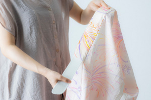 ピンクの襦袢に襟芯を入れる女性