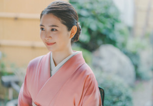 ピンクの色無地に伊達襟をつけた女性