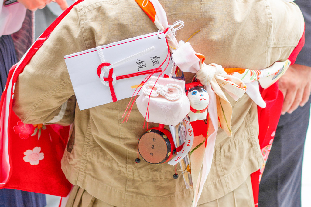 お宮参りの小物の犬張子とでんでん太鼓とお守りと紐銭と扇子
