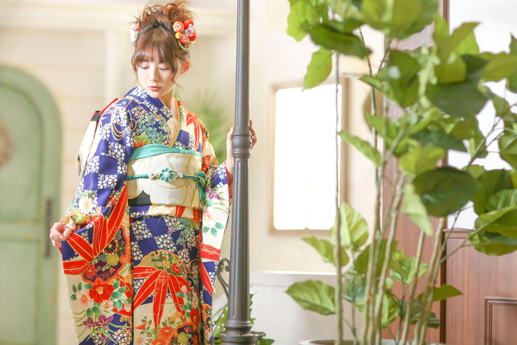 スタジオで成人式の後撮り撮影をする青い振袖を着た女性