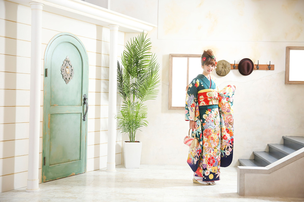 スタジオで成人式の後撮り撮影をする緑の振袖を着た女性