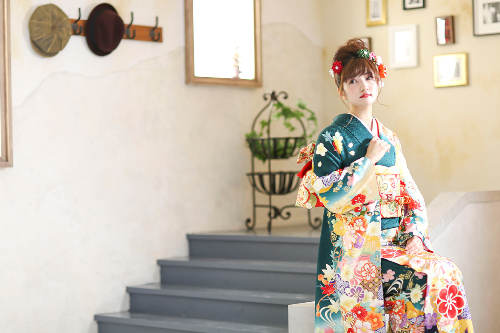 スタジオで成人式の後撮り撮影をする緑の振袖を着た女性