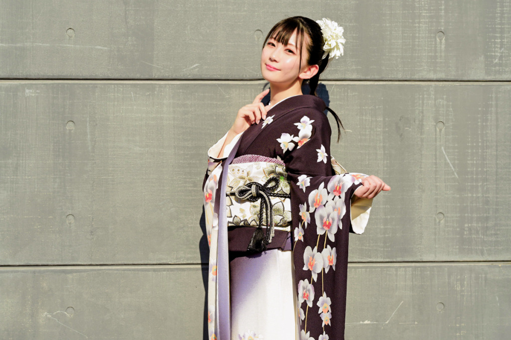 夏に濃い紫色の振袖を着た女性