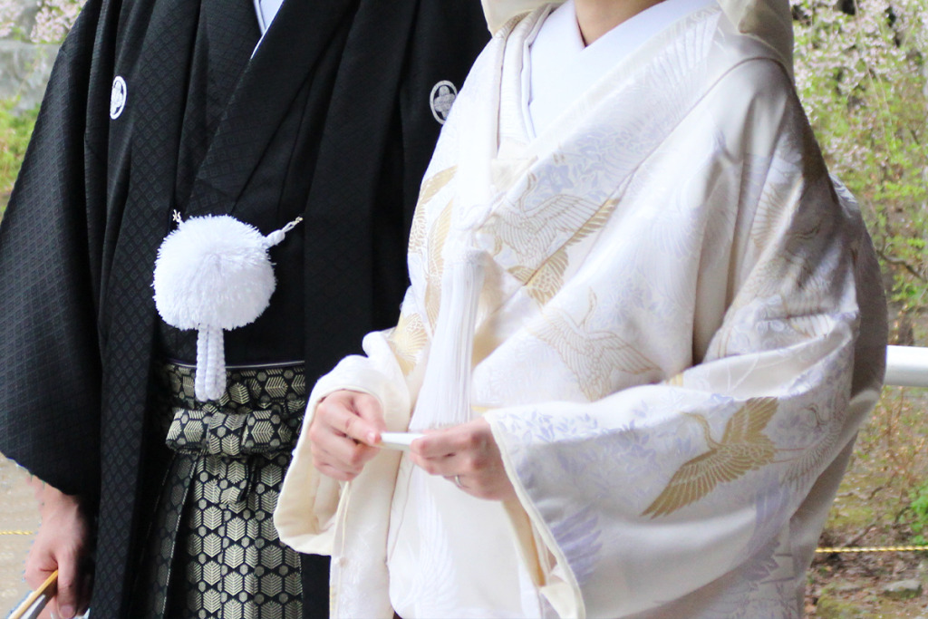 黒い紋付袴を着た男性と白無垢を着た女性