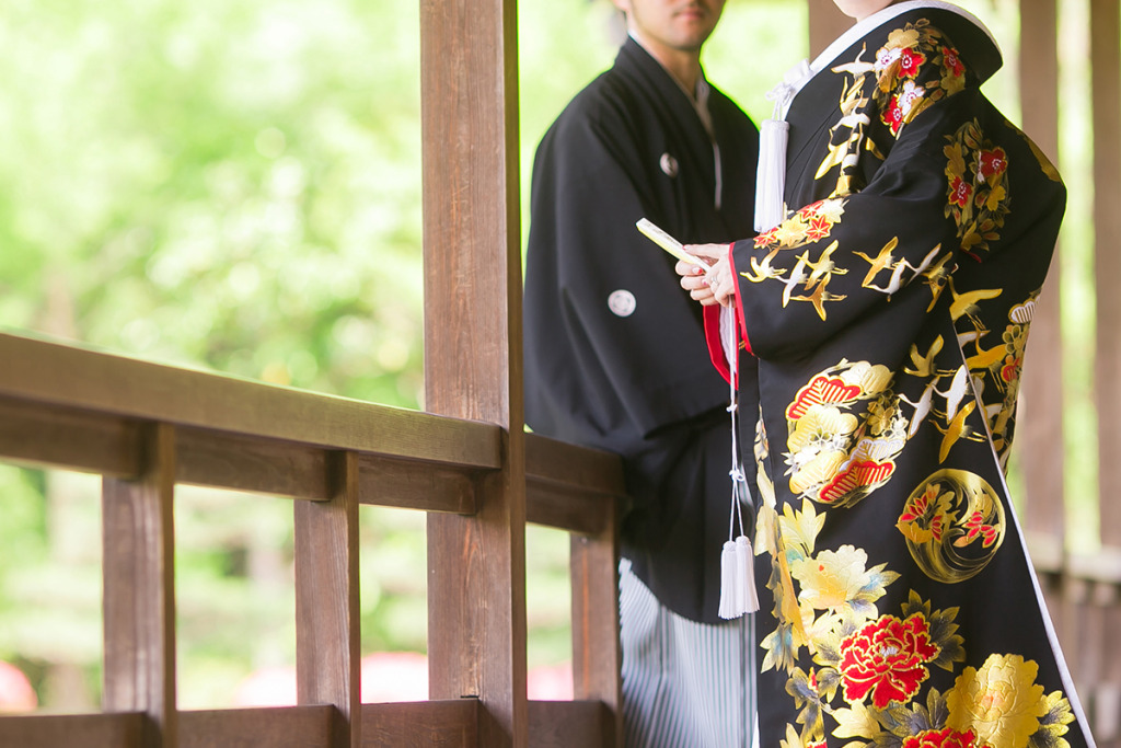 黒い色打掛を着た女性と黒紋付袴を着た男性