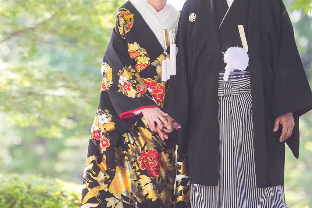 黒い色打掛を着た女性と黒紋付袴を着た男性