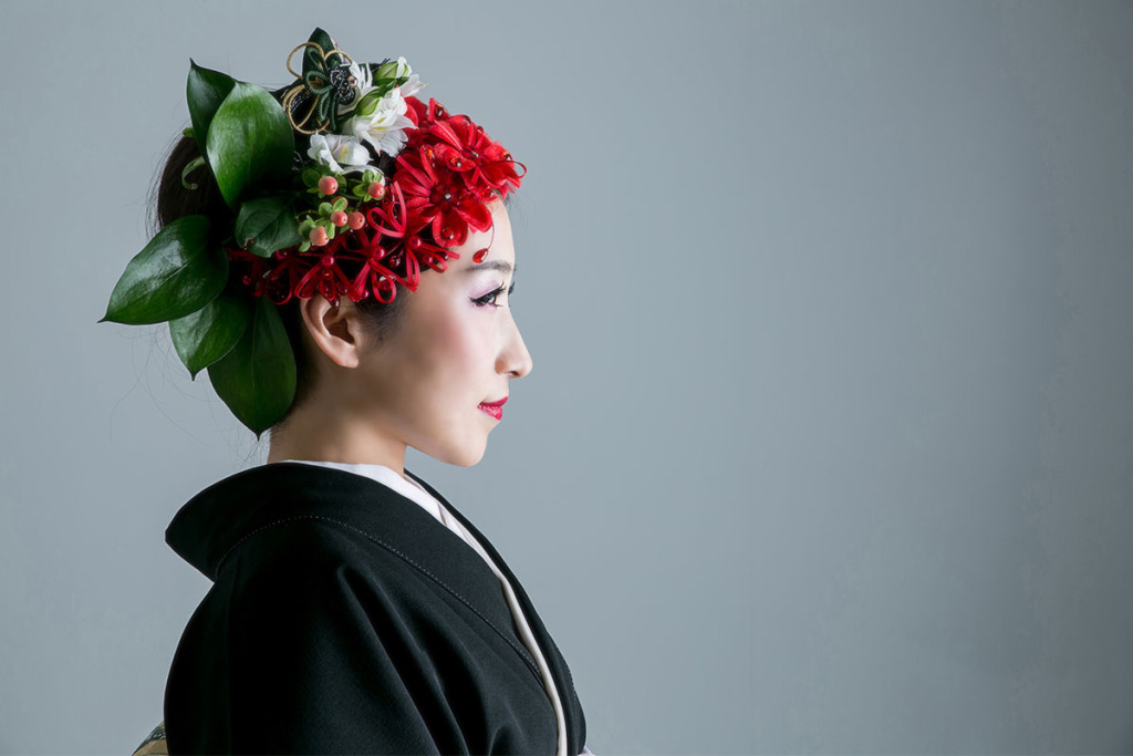 派手な髪飾りをつけた黒留袖の女性