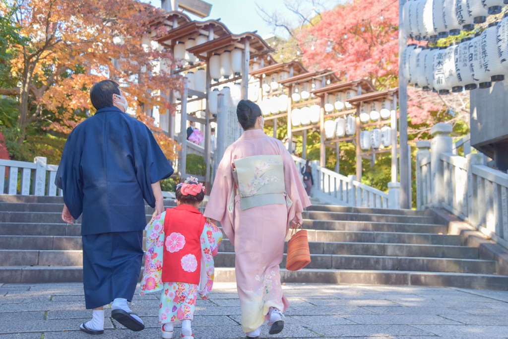 紺色の羽織着物を着た男性と赤い被布を着た女の子とピンクの着物を着た女性