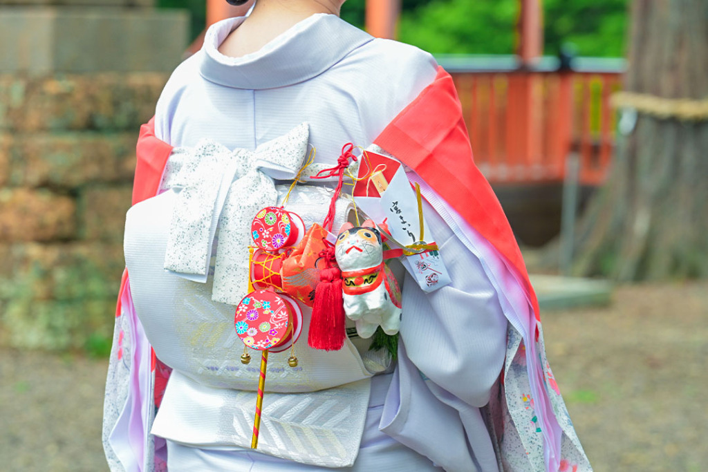 お宮参りの赤い産着を着た女性