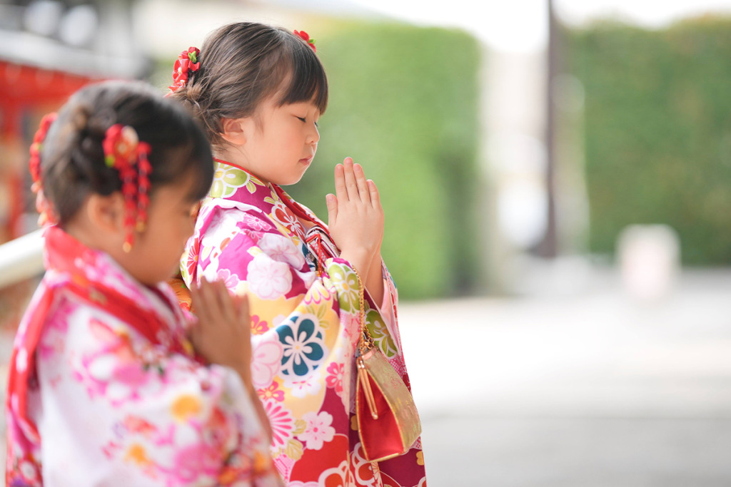 七五三の神社参拝で手を合わせる女の子