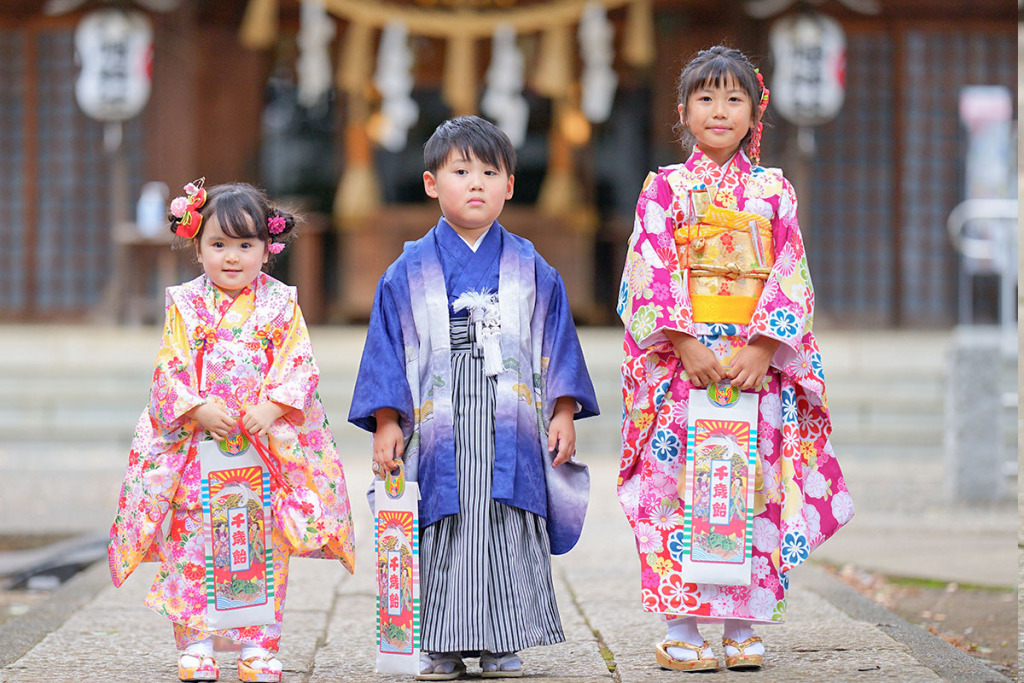 被布を着た女の子と青い羽織袴を着た男の子とピンクの四つ身着物を着た女の子