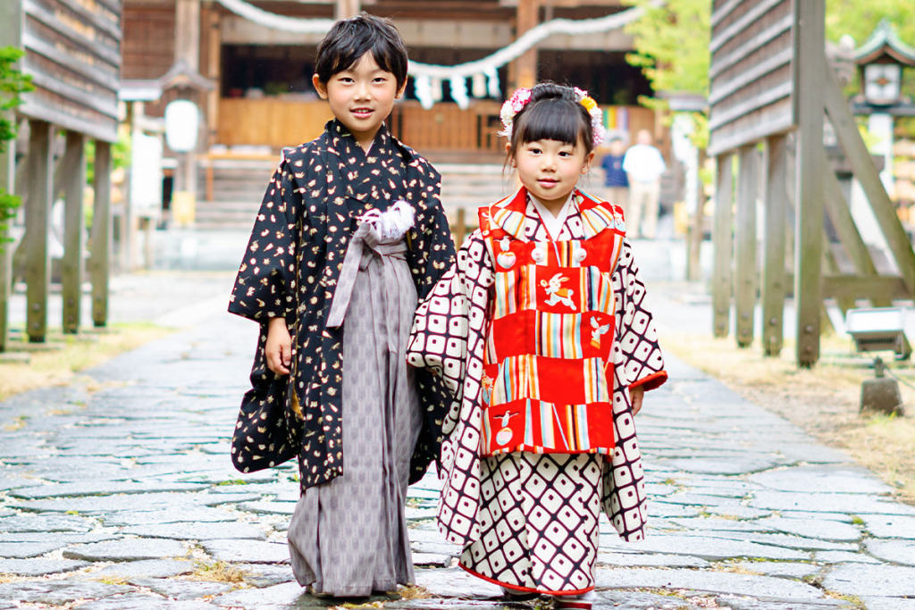 羽織袴を着た男の子と被布を着た女の子