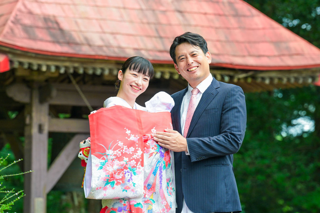 赤い産着を着た女性と紺色のスーツを来た男性