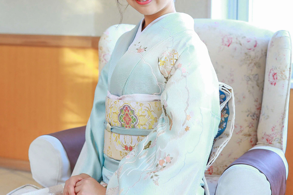 白い半衿を合わせた水色の訪問着を着た女性